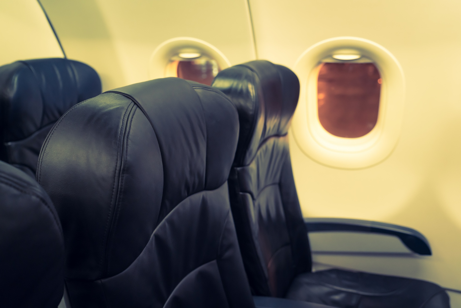 Black leather airplane seats by windows